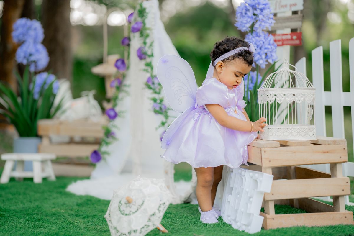 Toddler in a fairy dress at a garden party with flowers